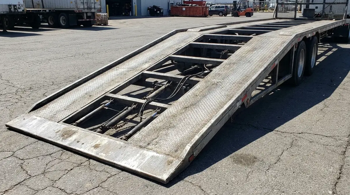 Hydraulic ramp of a car carrier lowered to the ground