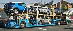 Open auto transport carrier loaded with vehicles for cross-country car shipping